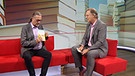 Dirk Kruse und Charly Hilpert sitzen auf einer Couch, wo Dirk Kruse seinen Buchtipp präsentiert | Bild: BR