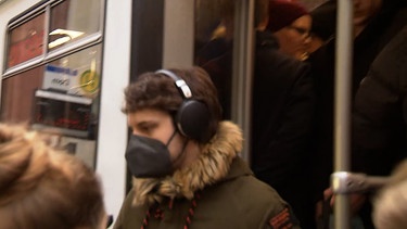 Mann mit Maske steigt aus Straßenbahn. | Bild: BR