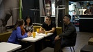 Zwei Angehörige eines Erdbebenopfers aus der Türkei sitzen mit ihrer Chefin und einer BR-Korrespondentin am Tisch. | Bild: BR