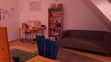 Ein Raum mit einer Couch, einem Bücherregal und einem Schreibtisch. | Bild: BR