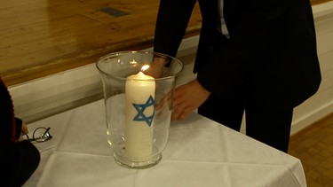 Eine Kerze mit Davidsstern brennt. | Bild: BR
