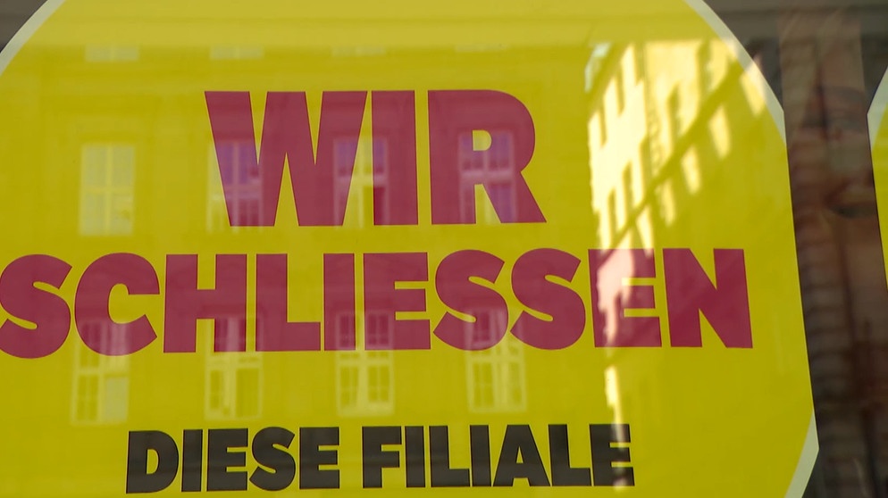 Schild in Schaufenster mit "Wir schließen diese Filiale". | Bild: BR