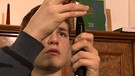 Junge schraubt Mundstück auf eine Klarinette. | Bild: BR