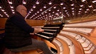 Ein Mitarbeiter eines Orgel-Herstellers testet die neue Orgel in der Würzburger Musik-Hochschule. | Bild: BR