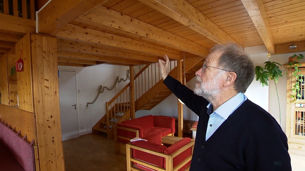 Prof. Gunter Adams zeigt einen Holzbekleideten Raum und seine Besonderheiten. | Bild: BR