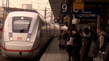 Ein ICE fährt in den Nürnberger Hauptbahnhof ein. Auf dem Gleis sind einige Reisenden bereit für den Osterurlaub. | Bild: BR