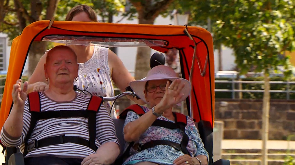 Zwei Seniorinnen sitzen in einer Rickscha. | Bild: BR