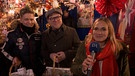 Zwei Mitglieder von "Viva Voce" werden von BR-Korrospondentin Annalena Sippl auf dem Nürnberger Christkindlesmarkt interviewt. | Bild: BR