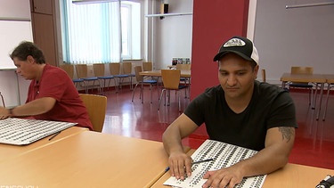 Eine Frau und ein Mann testen die Wahlschablone für Blinde | Bild: BR Fernsehen