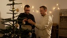 Matthias Drechsler und Hendrik Dietrich schmücken einen Weihnachtsbaum. | Bild: BR