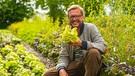 Johannes Schwarz, Biogärtner mit Faible für alte Gemüsesorten, hier mit einem seiner Lieblingssalate, der Goldforelle | Bild: André Goerschel