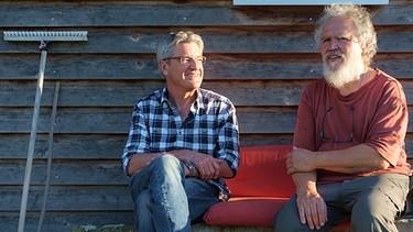 Franz Gernstl und Roqueforts-Produzent Norbert Fischer sitzen auf einer Gartenbank | Bild: megaherz