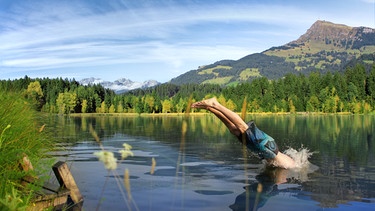 Ein Mann springt mit einem Kopfsprung in einen See. | Bild: stock.adobe.com/photog.raph