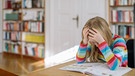 Ein Mädchen sitzt verzweifelt zuhause an den Hausaufgaben. | Bild: BR/Johanna Schlüter
