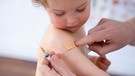 Ein einjähriges Mädchen weint nach einer Kinderimpfung gegen Meningokokken und trägt ein Pflaster auf dem Arm. | Bild: picture-alliance/dpa