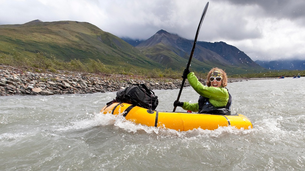 Frau in einem Schlauchboot beim Packrafting im Sanctuary River in Rainy Weather, Denali National Park & Preserve, Alaska  | Bild: picture alliance / Design Pics | Joe Stock