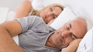 Ein schlafendes Paar in einem Bett. | Bild: stock.adobe.com/Rido