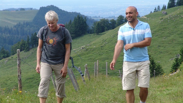 Werner Schmidbauer (links) und der Kabarettist Django Asül auf ihrer Wanderung hinauf zum Friedenskreuz am Pasterkopf (ca. 1270 m) im Inntal. | Bild: BR/Werner Schmidbauer