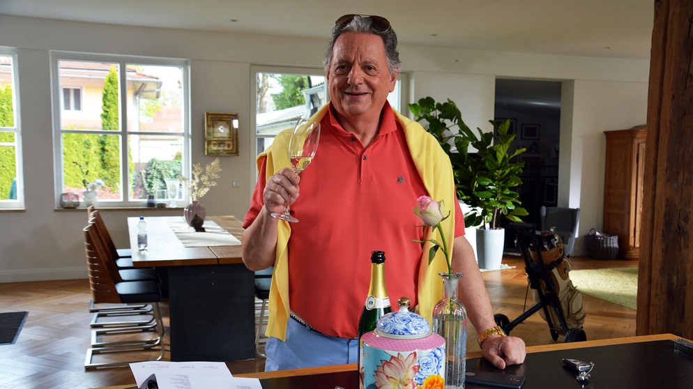 Günter Grünwald mit einem Glas Champagner im Sketch "Rentenbescheid". | Bild: BR/Helmut Milz
