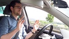 Person hebt die Hände vom Steuer eines autonom, also selbstfahrenden Autos.  | Bild: BR