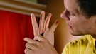 Gut zu wissen-Experimentator Philip Häusser malt sich rote Striche auf die Finger. | Bild: BR