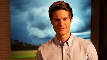 "Gut zu wissen"-Moderator Philip Häusser Hintergrund Bild Landschaft mit dunklen Wolken. Diese Sendung geht es um die Wetterfühligkeit. Gibt es sie wirklich?  | Bild: BR/Gut zu wissen
