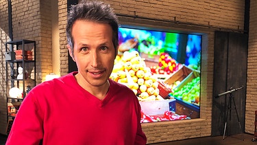 "Gut zu wissen"-Moderator Willi Weitzel. Hintergrund ein Bild mit Gemüse. Was kosten Lebensmittel wirklich?  | Bild: BR/Gut zu wissen