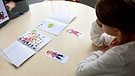 Ein Mädchen löst eine Aufgabe. Spielerische Versuche sollen erklären, was Kinder unter gerecht verteilen verstehen. | Bild: BR/Gut zu wissen