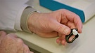 Ohrstecker mit Sensoren. Mit diesen Ohrsteckern haben Ärzte des Klinikums rechts der Isar in München den Zustand von Covid-19-Patienten testweise überwacht.  | Bild: BR/Gut zu wissen