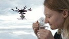 Frau riecht an einem Behälter. Hintergrund Drohne mit künstlicher Nase. Wie gut können Maschinen riechen? | Bild: BR/Gut zu wissen