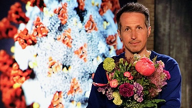 "Gut zu wissen"-Moderator Willi Weitzel mit Blumen in der Hand. Thema der Sendung: Geruchsverlust durch Corona | Bild: BR/Gut zu wissen
