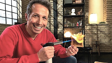 Willi Weitzel mit Bunsenbrenner und Toastbrot in Flammen. Wie entstehen gefährliche Stoffe beim Erhitzen.  | Bild: BR/Gut zu wissen
