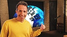 "Gut zu wissen"-Moderator Willi Weitzel zeigt im Hintergrund auf ein Bild mit der Internationalen Raumstation ISS. Matthias Maurer startet zu seiner Mission.  | Bild: BR/Gut zu wissen