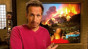 "Gut zu wissen"-Moderator Willi Weitzel im Hintergrund Bild vom Vulkanausbruch auf La Palma. | Bild: BR/Gut zu wissen