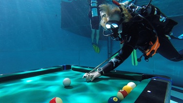 Eine Taucherin bei einer Unterwasser-Snooker-Partie  | Bild: BR/South & Browse