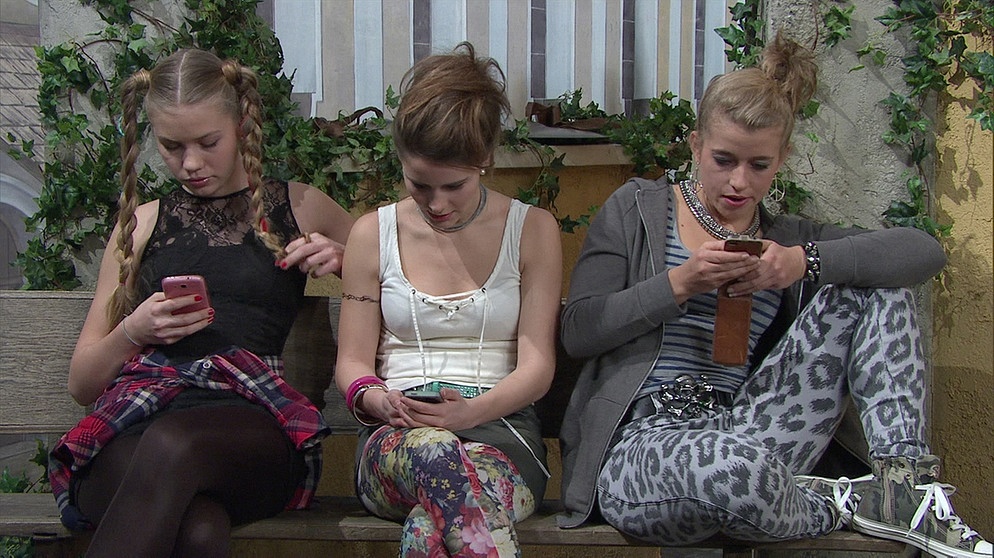 Komödienstadel - 1001 Nacht in Tegernbrunn: Drei Teenager aus dem Dorf mit ihren Smartphones auf einer Bank sitzend. (Von links: Paulina Schwab, Josephine Roy und Janina Möller.) | Bild: BR