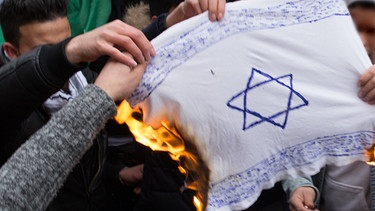 Archivbild: Teilnehmer einer Demonstration verbrennen in Berlin eine Israel-Flagge | Bild: pa/dpa/Jüdisches Forum für Demokratie und gegen Antisemitismus e.V.
