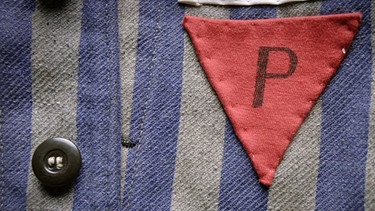 KZ-Häftlingskleidung mit einem roten Dreieck und einem P darin | Bild: BR / Kontrovers