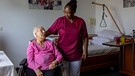 Altenpflegerin aus Ghana spricht mit Rentnerin | Bild: picture alliance/dpa | Helmut Fricke