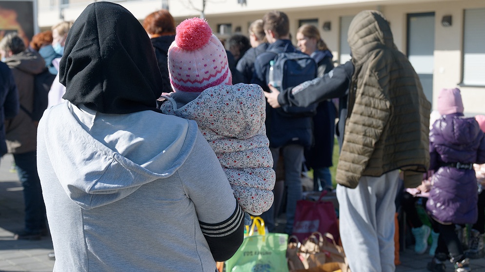 Geflüchtete aus der Ukraine stehen mit ihrem Gepäck vor den Gebäuden eines Flüchtlingsheims. | Bild: picture alliance/dpa | Henning Kaiser