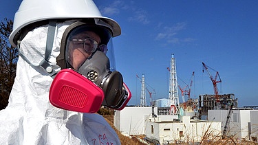 Besucher mit Atemmaske vor dem Kraftwerk Fukushima | Bild: Yoshikazu Tsuno, Pool/AP/dapd