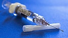 Eine Impfspritze mit der Aufschrift Covid-19 (Symbolbild) | Bild: picture-alliance/dpa