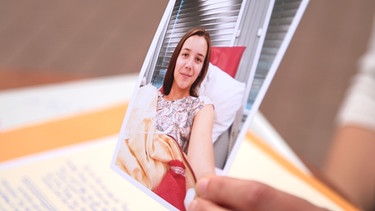 Die Stammzellenspenderin Christiane Kruck hält ein Foto hoch, das sie während ihrer Stammzellenspende zeigt. | Bild: BR