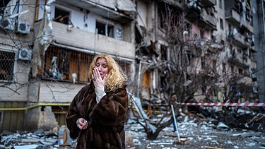 Eine Frau steht in Kiew vor einem Haus, das bei einem Raketenangriff zerstört wurde.
| Bild: dpa-Bildfunk