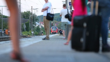 Wartende Bahnreisende am Bahnhof, der Zug fährt gerade ein | Bild: picture alliance / dpa | Karl-Josef Hildenbrand