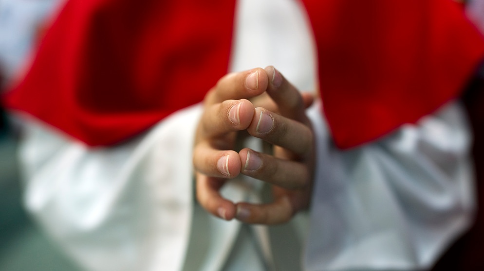 Ein Messdiener betet, Nahaufnahme auf die Hände | Bild: picture alliance / AFP Creative | Johannes Eisele