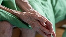 Eine pflegebedürftige Seniorin sitzt auf ihrem Bett. | Bild: picture alliance/dpa | Monika Skolimowska