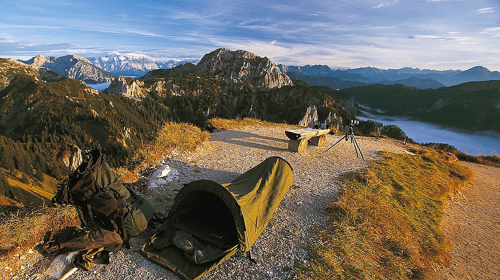 Ein Camper hat sein Zelt in der Natur aufgeschlagen | Bild: picture-alliance / DUMONT Bildarchiv / Markus Heimbach