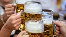 Menschen stoßen mit Bierkrügen an. | Bild: picture alliance/dpa | Matthias Balk