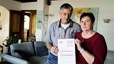 Ehepaar zeigt ein Schreiben ihres Energieanbieters | Bild: BR / Kontrovers | Johannes Lenz